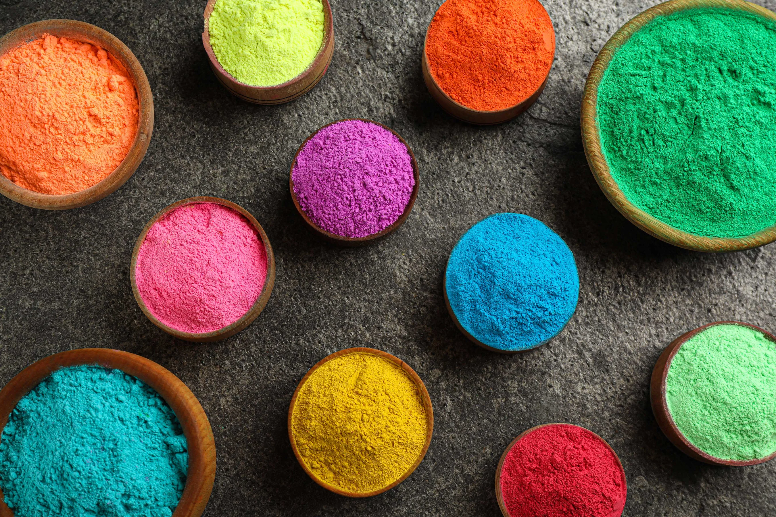 Colorful powder dyes on grey background, flat lay. Holi festival
